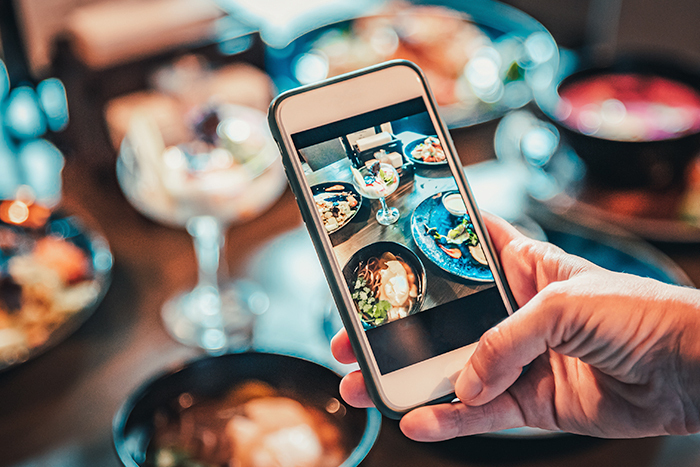 Close-up of a person taking a picture of food with their phone