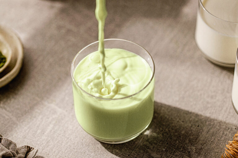Pistachio milk being poured into a glass.